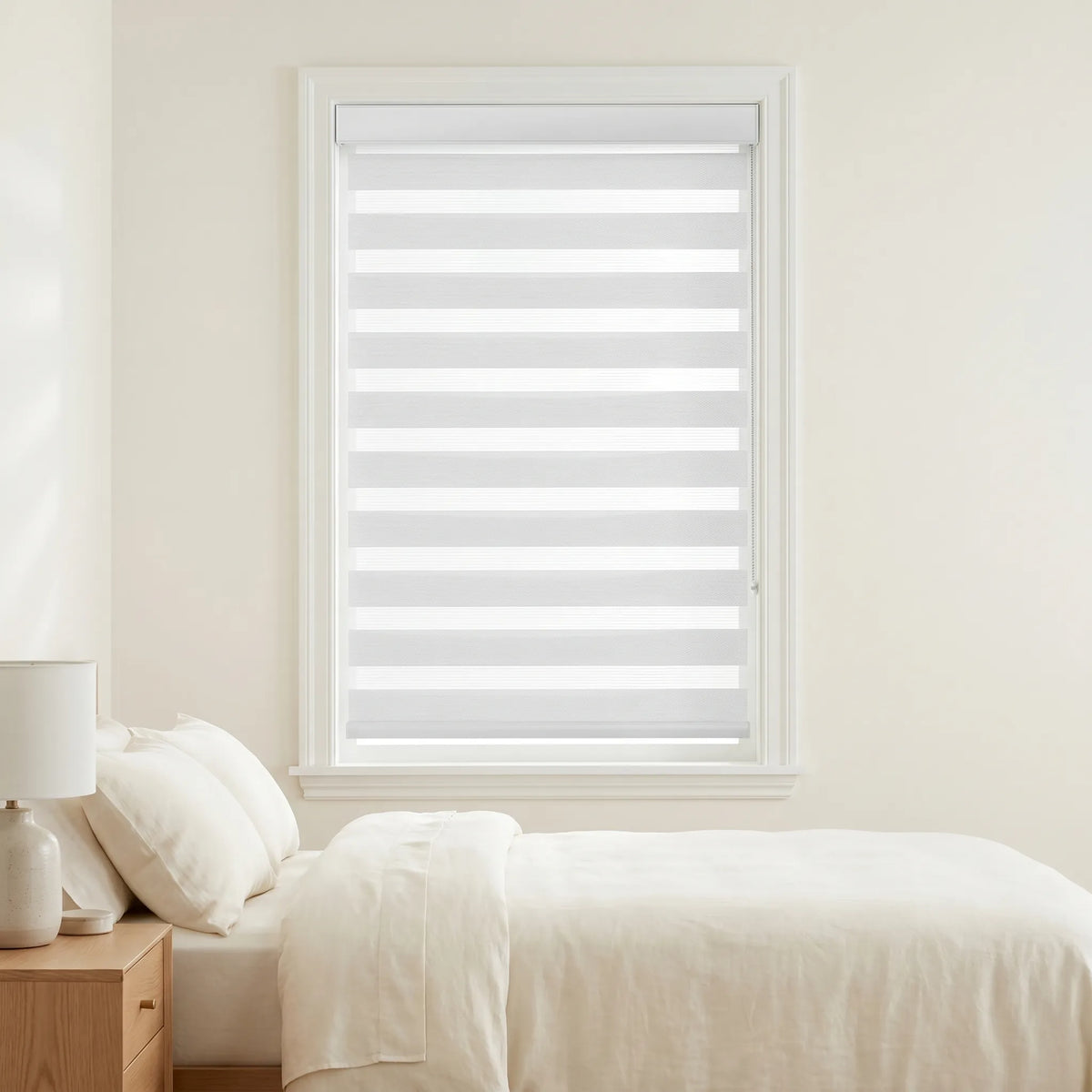 Zebra Solar Roller Shades add soft, creamy white ambiance to this serene bedroom retreat with UV protection and stylish ease.