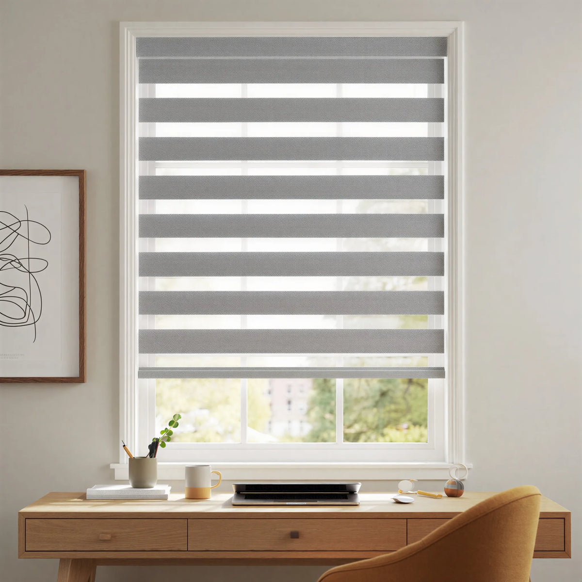 Elegant gray and white striped Zebra Room Darkening Roller Shades adorn this cozy living space, perfect for working or relaxing.