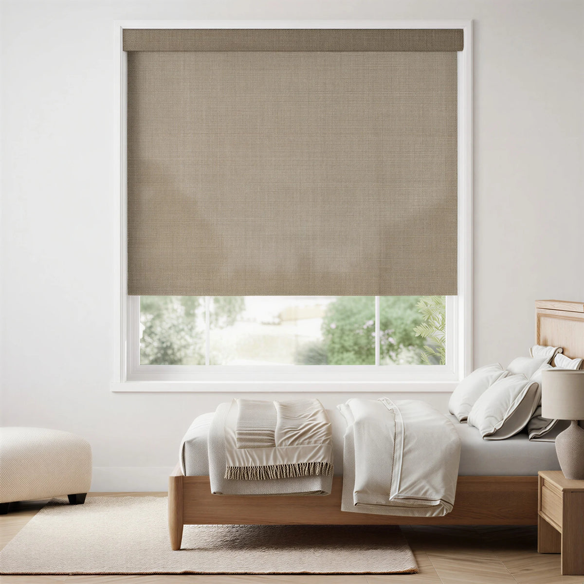 Gray-brown Flagstone Taupe Luxe natural light filtering roller shades in a bedroom, providing a soft glow.