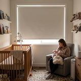 Gray Classic Blackout Vinyl Roller Shade blocking light in a nursery while a mother holds her baby
