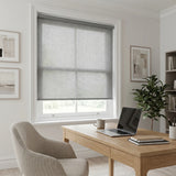 Classic Fabric Light Filtering Roller Shades in gray provide a calming atmosphere for this well-lit office space with natural light and greenery.