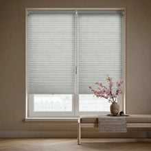 Load image into Gallery viewer, Showcasing Gray (Cool Silver) 3 8 Inch Budget Single Cell Light Filtering Cordless Shades in a modern living space, protecting furniture from fading while maintaining a bright feel.
