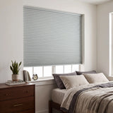 Gray Elegant-Dove Signature Blackout Double Cellular Shade on a bedroom window beside a wood nightstand