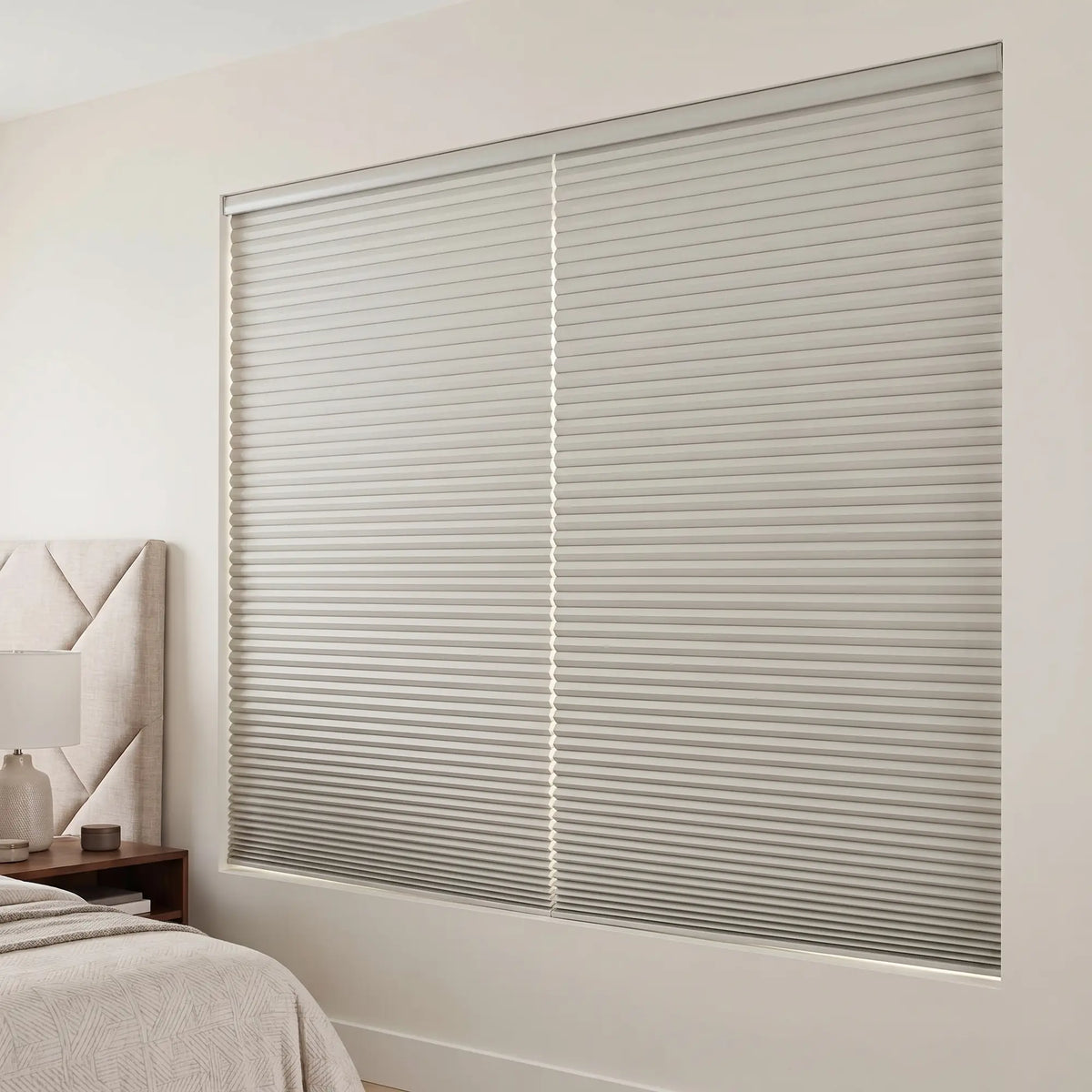 Gray Elegant-Dove Signature Blackout Single Cellular Shade on a bedroom window beside a mid-century nightstand