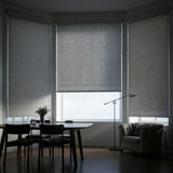 Gray Jerusalem Grey Luxe room darkening shades installed in a contemporary dining room bay window, providing privacy.