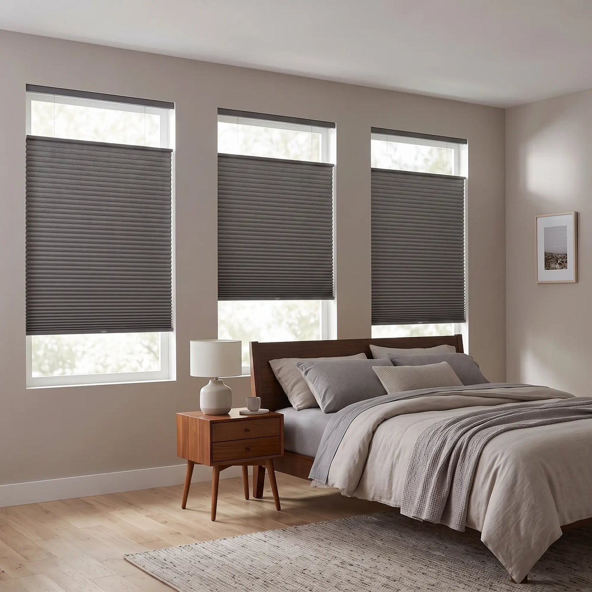 Gray Raindance Signature Blackout Single Cellular Shade on a bedroom window beside a mid-century nightstand