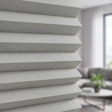 Simplistic Cordless Pleated Shades bring a touch of elegance to this serene space, where gray tones and natural light harmonize beautifully amidst white walls and subtle decor.