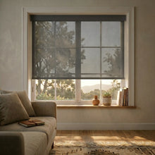 Load image into Gallery viewer, Functional Grey Black Signature solar roller shades in a cozy living room setting, providing high-performance solar protection and a sophisticated, dark aesthetic.
