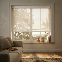 Load image into Gallery viewer, Warm White Sandstone Beige Signature solar roller shades in a contemporary living space, offering a perfect balance of privacy and visibility through a 5% mesh fabric.
