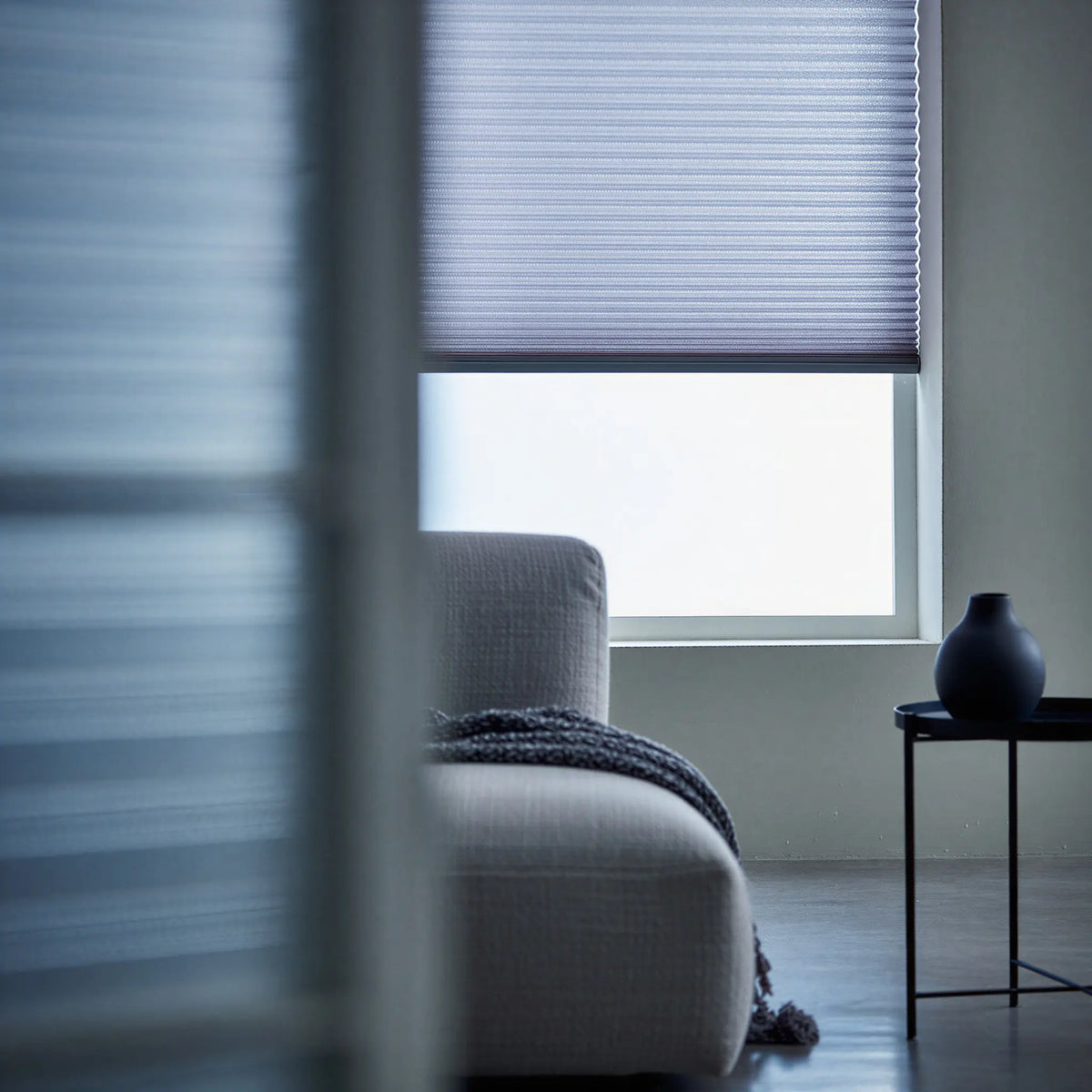 A look at Light Blue (Royal Grey) 7 16 Inch Double Cell Light Filtering Shades inside a peaceful living space, protecting furniture from fading while maintaining a bright feel.