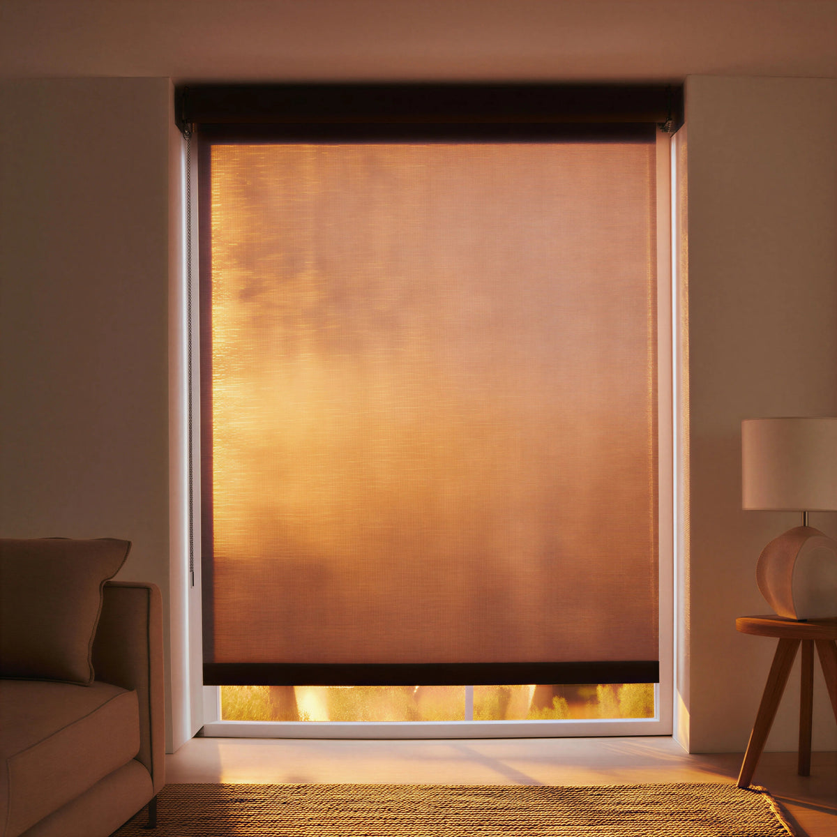 Evening sunset shot of Luxe natural light filtering roller shades, showing privacy and elegant light diffusion.