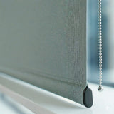 Detailed close-up of the hem bar and fabric texture of a Signature blackout roller shade in a sage green tone.