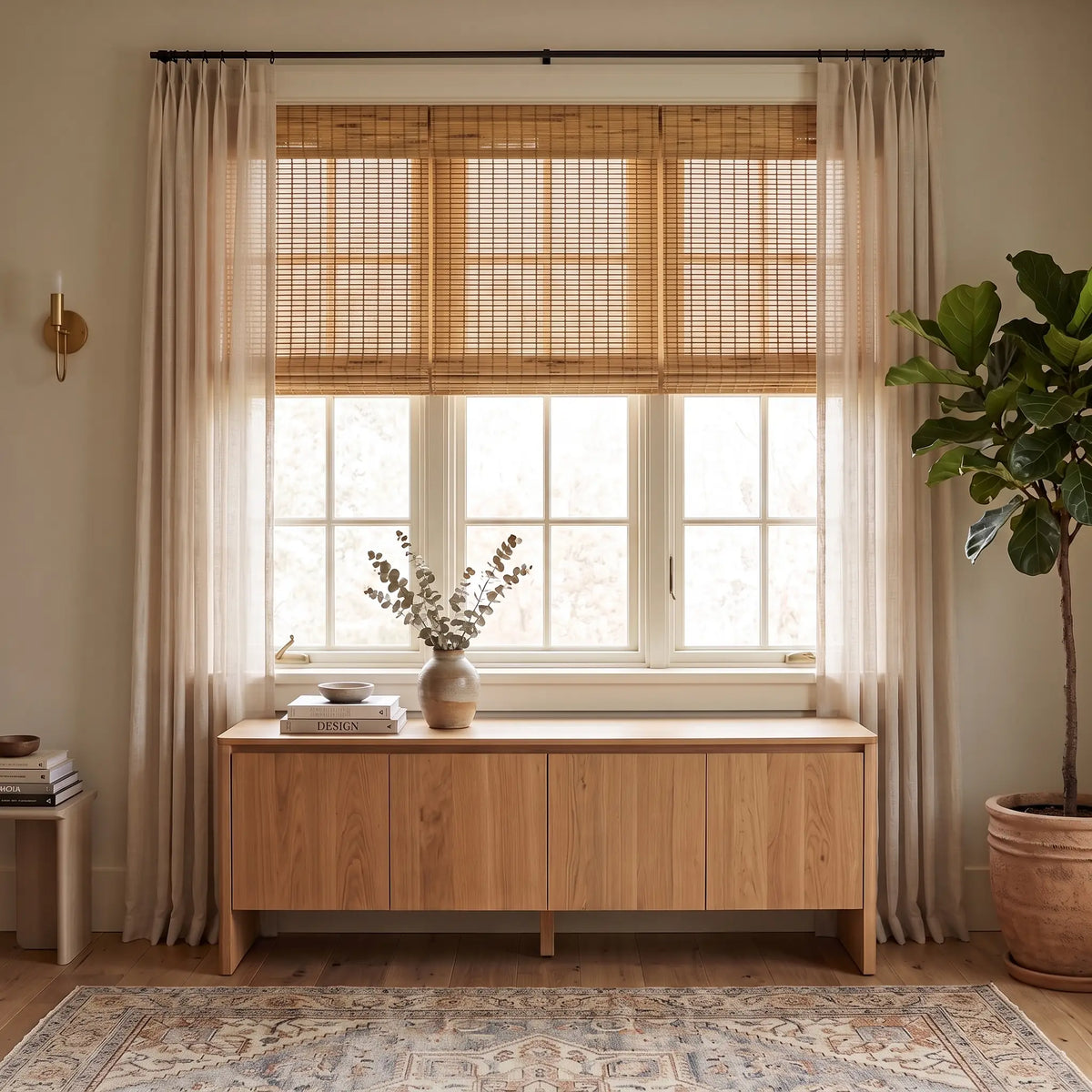 Natural Bamboo Shade layered with sheer curtains above a wood console table
