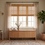 Natural Bamboo Shade layered with sheer curtains above a wood console table