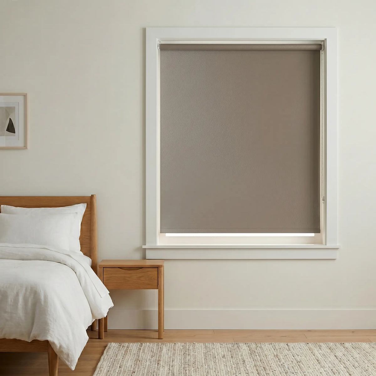 Economy Basic Vinyl Blackout Roller Shades installed in a serene white bedroom, providing cozy darkness and subtle elegance.