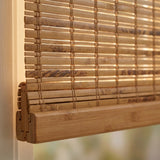 Elegance abounds with this Cordless Woven Wood Shade, expertly crafted from natural bamboo, beautifully complementing the soft warmth of Terra Brown hues and filtering bright sunlight into a serene room setting.