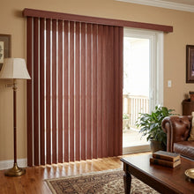 Load image into Gallery viewer, Woodtone Faux Wood PVC Vertical Blinds beautifully complement the brown tones of this inviting outdoor patio, effortlessly filtering natural light through a sliding glass door.
