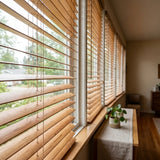 Hardwood Cordless Horizontal Blinds add warmth and texture to this inviting room featuring a brown window shade, white bench, and lush greenery