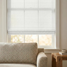 Load image into Gallery viewer, Cordless Woven Wood Shades bring a touch of sophistication with their textured white design, perfectly complementing plush furniture and warm lighting in this serene sitting room.
