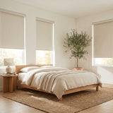 Elegant Classic Fabric Blackout Roller Shades in Creamy White bring serenity to this modern bedroom with clean lines and natural light
