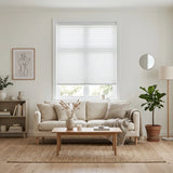 Simplistic Cordless Pleated Shades in White effortlessly complement the beige sofa and potted plants, softening the room's ambiance while allowing natural light to dance across the space.