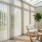 Natural sunlight hits the White (Wanderlust Gypsum) Signature Pvc Vertical Blinds in this serene living space, delivering sleek functionality and room-darkening capabilities.